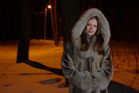 Young female walking in a winter forestの写真素材