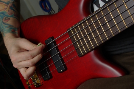 Playing on red bass guitar