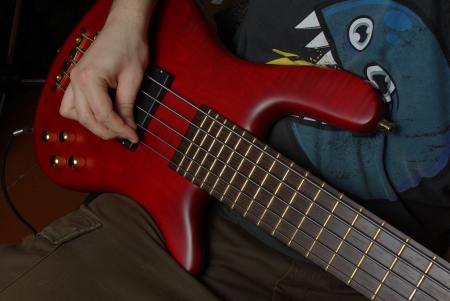 Red bass guitar in handの写真素材