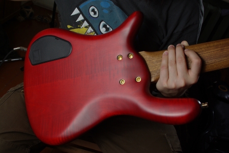 Bass guitar with red body in handの写真素材