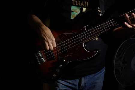 Man playing an fretless brown bass guitarの写真素材