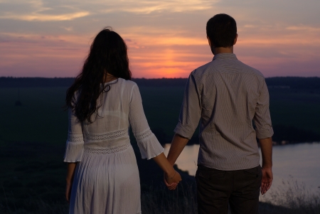 Young sweethearts looking at the sunsetの写真素材