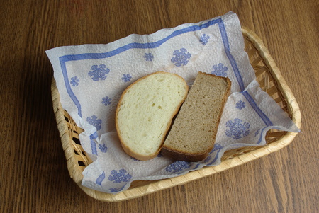 Two slices of bread in wicker basket on napkinの写真素材