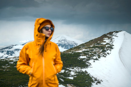 Travel concept and background. Defocused tourist on foreground and amazing snowy mountain view. Traveler woman hiking and walking outdoors by nature.の写真素材