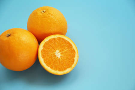 Half-cut orange placed on a light blue backgroundの写真素材