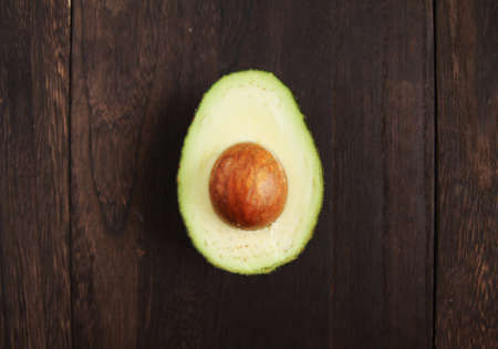 Avocado cut in half on a wooden tableの写真素材