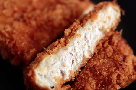 High-calorie pork cutlet fried in oil on a blue table