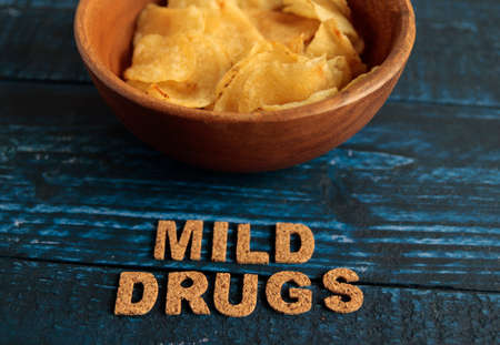 Potato chips on a blue table with a lot of calories called mild dragの写真素材