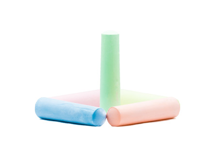 Green colored chalk standing inside 4 colored chalks on white backgroundの写真素材