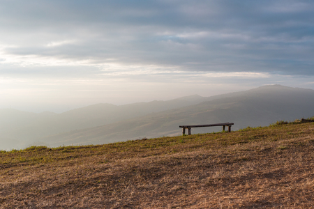 A chair at the edge of the mountain under the beam of morning light.の写真素材
