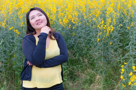 portrait of happy beautiful fat woman posing in sunn hemp garden.の写真素材