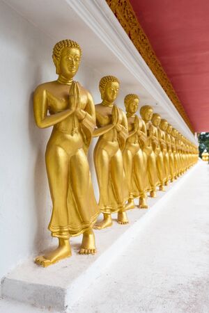 Golden Buddha Statue on the wall in public temple, Thailand.の写真素材