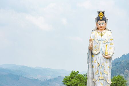 Quan Yin, the goddess of compassion and mercy, statue standing on the top of hill.の写真素材