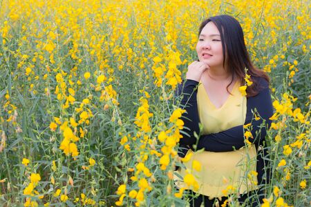 portrait of happy beautiful happy fat woman posing in sunn hemp garden.の写真素材