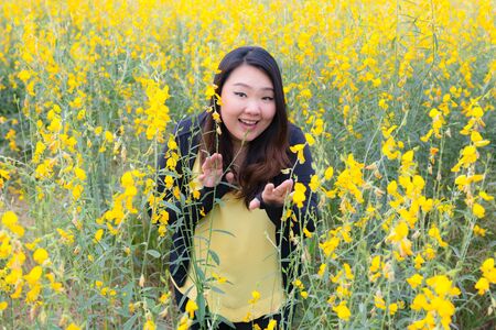 Portrait of beautiful happy fat woman touching sunn hemp happily in the flower gardenの写真素材
