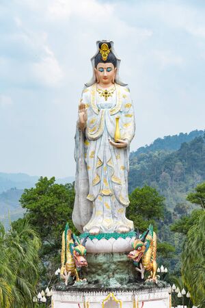Quan Yin, the goddess of compassion and mercy, statue standing on the top of hill.の写真素材