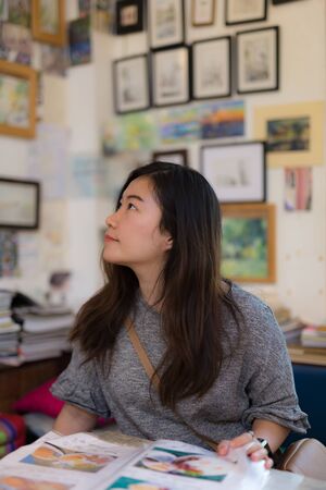 beautiful smiling woman looking away in  coffee shop while ordering a cup of tea.の写真素材