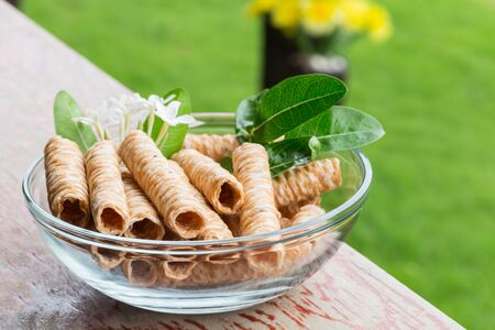 Crispy rolled wafer sticks, traditional dessert in Thailand, are collocated in the transparent bowl.の写真素材