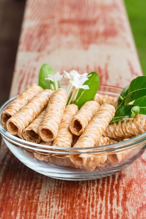 Crispy rolled wafer sticks, traditional dessert in Thailand, are collocated in the transparent bowl.の写真素材