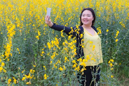 portrait of happy beautiful fat woman posing in sunn hemp garden.の写真素材