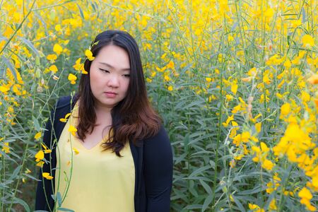 Portrait of beautiful fat woman feeling exhausted in the sunn hemp gardenの写真素材