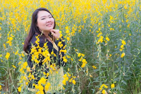 portrait of happy beautiful happy fat woman posing in sunn hemp garden.の写真素材