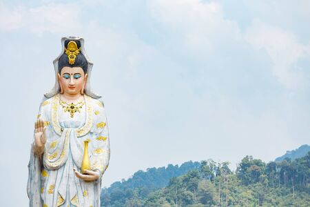 Quan Yin, the goddess of compassion and mercy, statue standing on the top of hill.の写真素材