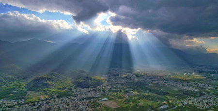 The sun's rays make their way through the clouds over the city.
