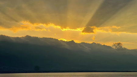 Sunset over the sea with dark clouds and rays of light.の写真素材