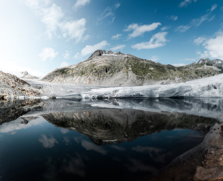 Mountains reflected in the water of a lake in the Alps.の写真素材