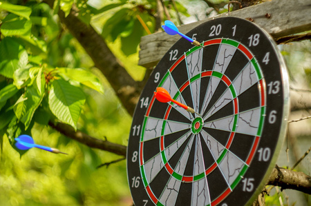 outdoor flying darts game with blurry green background