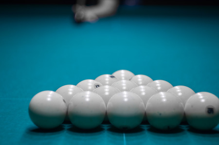 billiard green table in hall with white balls with man handの写真素材