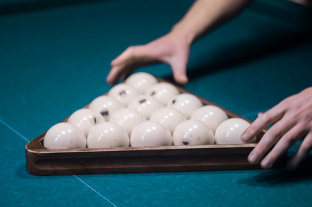 billiard green table in hall with white balls with man hand