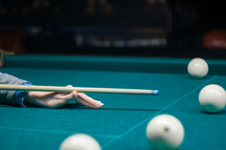 billiard green table in hall with white balls with man handの写真素材