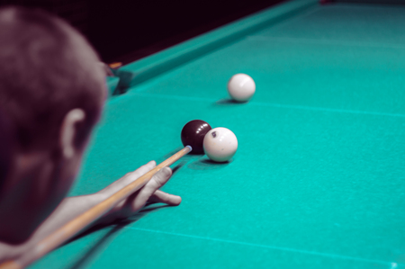billiard green table in hall with white balls with man handの写真素材