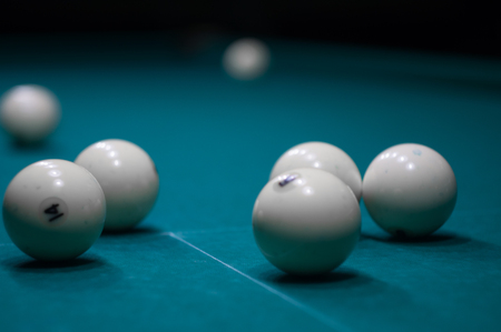 billiard green table in hall with white balls with man handの写真素材