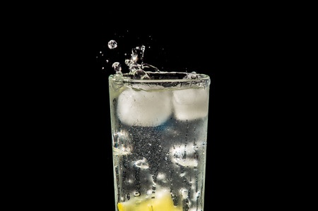 water splash with lemon and ice on blackの写真素材