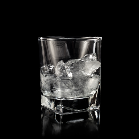 glass for alcohol with pure ice isolated over black backgroundの写真素材