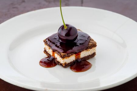 waffle cake with cherry and syrup on white plateの写真素材