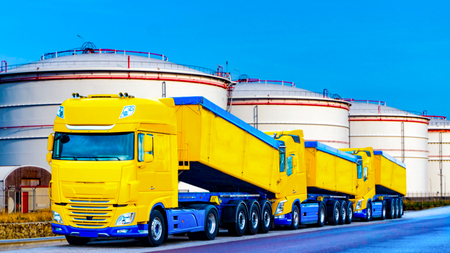 On the road for transportation of grain. the yellow truck with the trailer. Agricultural silos .Tank farm. Commercial transport. truck transport container.の写真素材