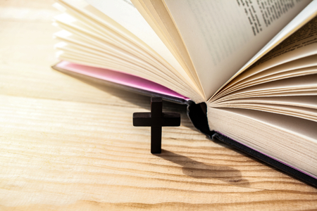 Bible lying on wooden surface. Holy Bible book. Wooden crucifixの写真素材