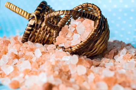 Himalayan Salt on turquoise surface. Pink spa. in a basket. Salt on the table in the basketの写真素材