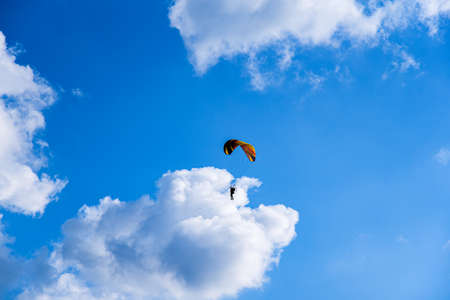 Paraglider is flying over the high mountains. Paragliding on beautiful sky backgroundの写真素材