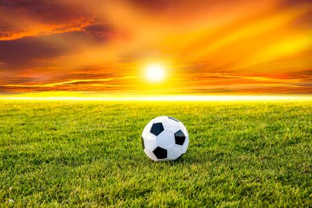 Football or soccer ball at the kickoff of a game with sunsetの写真素材