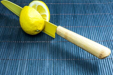 Knife blades cut the lemon into two halves. Yellow on black background, Fresh lemons fruitsの写真素材