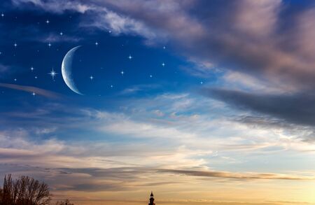 Moon in bright clouds of sunset sun. New moon, moon in the blue sky new moon in the clouds