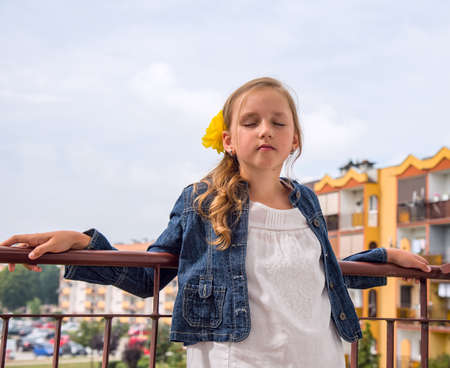 model girl on the balcony of her home . the child is happy on vacationの写真素材