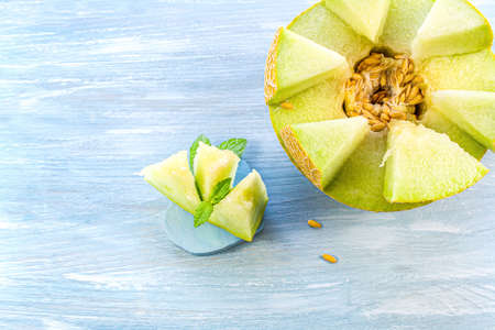 Sliced melons with mint. Sweet melon half on the woodの写真素材