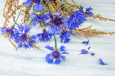 Bright blue flowers made of cornflower on a wooden background