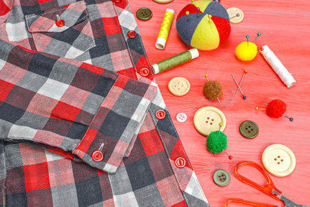 Clothing accessories, thread scissors and buttons on red background